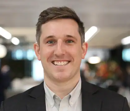 Smiling businessman in professional attire promoting new business success.