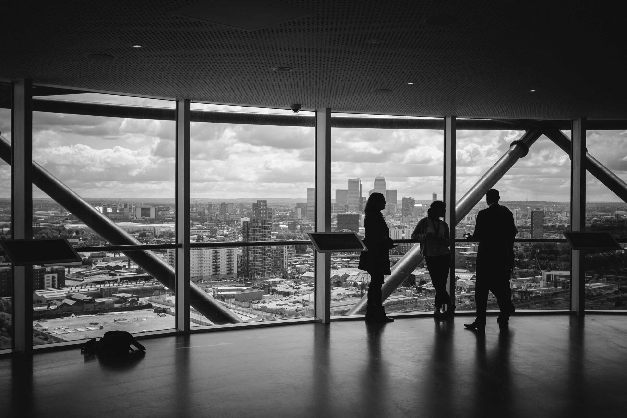 People discussing business strategies in modern office with city skyline view.