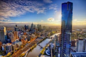 Aerial view of Melbourne city skyline with modern skyscrapers and Yarra River at sunrise.