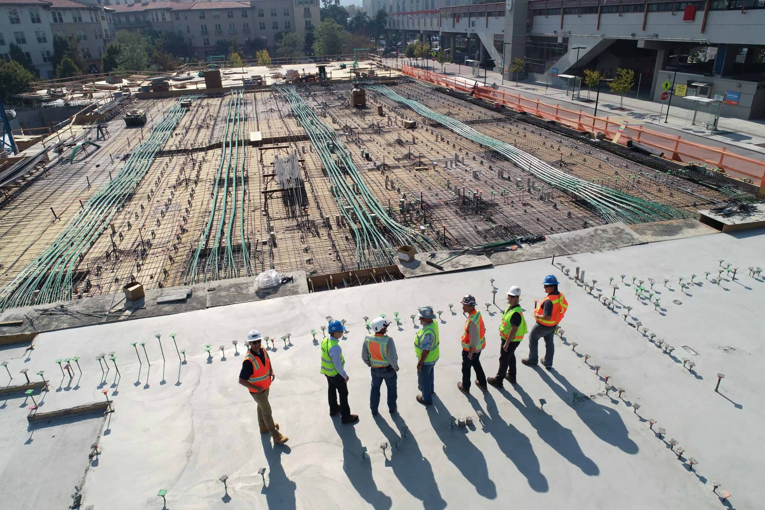 Construction team on a high-rise building site collaborating on new business development.